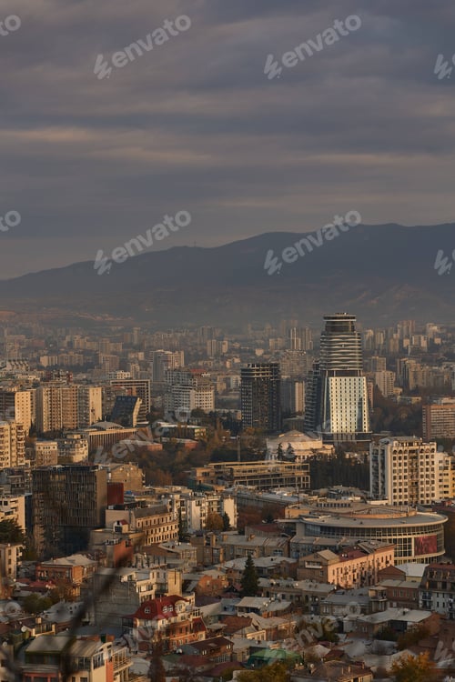 Preview: Scenic view of Tbilisi surrounded by majestic mountains in the distance at sunrise in Georgia