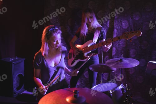 Preview: Female drummer performing with guitarist in nightclub