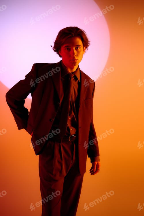 Preview: Young man in stylish suit poses dramatically against vibrant backdrop