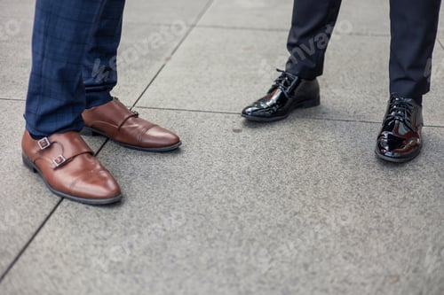 Preview: Closeup of two pairs of feet in businessman shoes in financial district