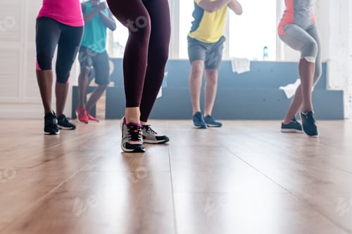 Preview: Cropped view of multicultural dancers exercising movements of zumba in dance studio