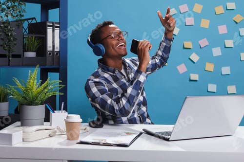 Preview: Relaxed company employee doing karaoke while sitting in office workspace.