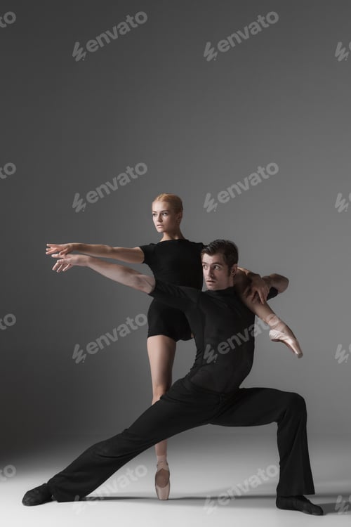 Preview: two young modern ballet dancers on gray studio background