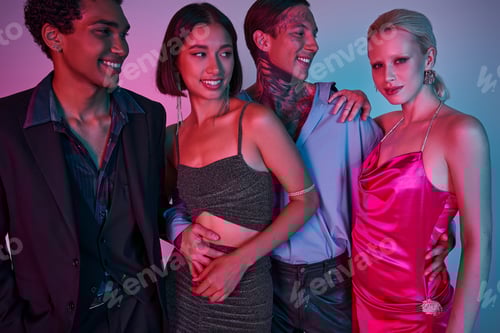 Preview: cheerful multicultural friends in festive attire hugging while celebrating Christmas on purple pink