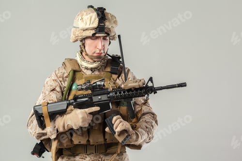 Preview: Soldier stands with firearm and gear in a studio setting during training session