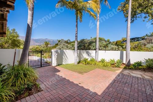 Preview: the brick patio of a house has many trees and a fence