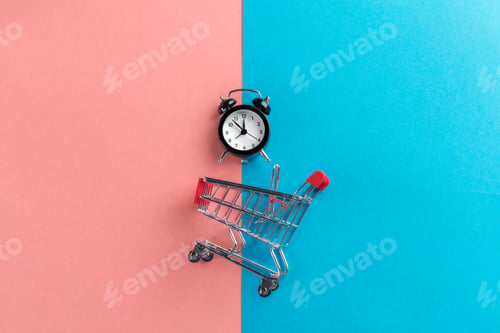Preview: Small shopping cart with alarm clock. Shopping time concept