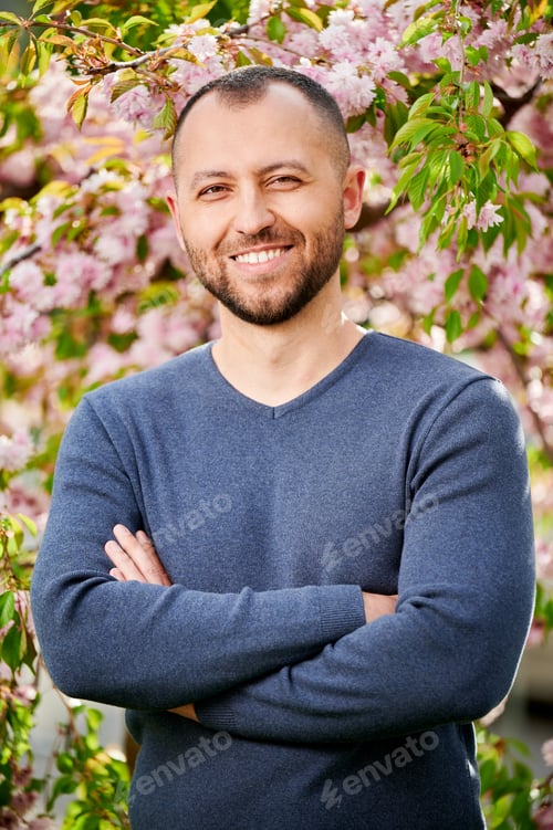 Preview: Man allergic enjoying after treatment from seasonal allergy in front of blossom tree at spring.