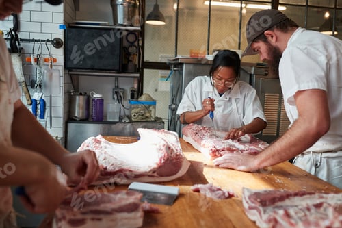 Preview: Three butchers preparing meat,cuts of meat to sell at a butcher's shop