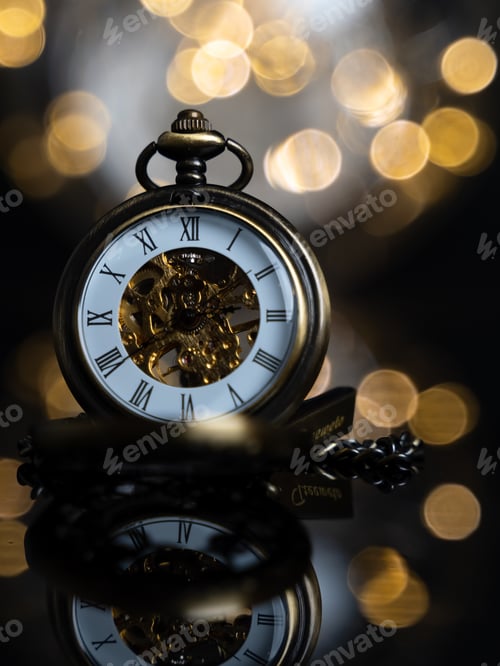 Preview: Closeup of gold pocket watches with background of light blurs