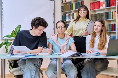 Preview: Group of teenage students with female teacher study inside classroom library