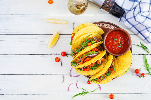 Vista previa: Mexican tacos with corn tortilla and meat on wooden background. Top view