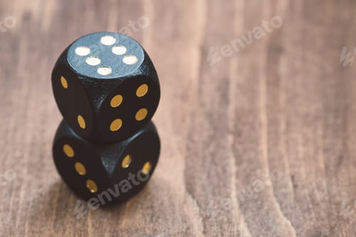 Preview: Close-up of black dice on a wooden table