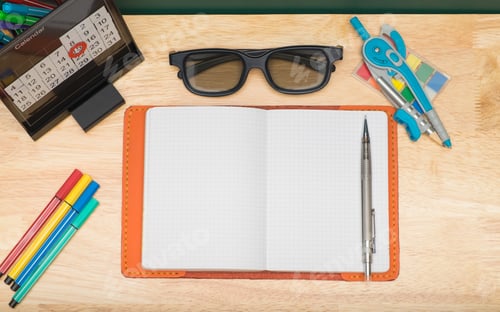 Preview: Top view of open notebook with Compasses, eyeglasses,calendar on wooden table
