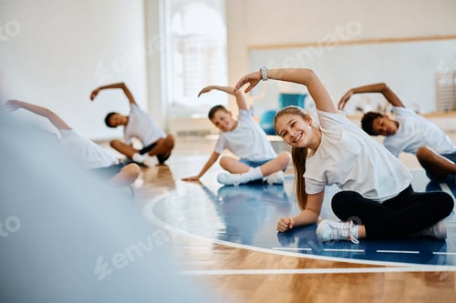 Preview: Happy elementary student and her classmates having PE class at school gymnasium.