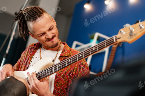 Preview: Young man guitar player sitting and performing on a couch
