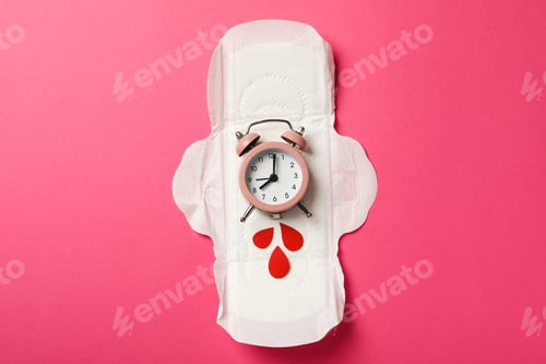 Preview: Menstrual pad with clock and red drops on pink background