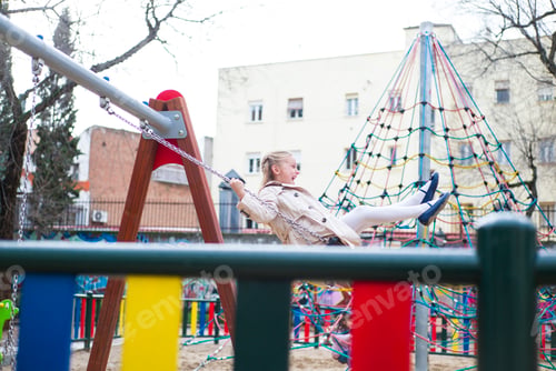 Preview: Smiling girl swinging in park