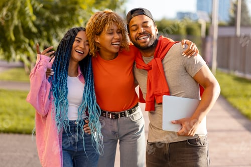 Preview: Group attractive positive African American friends in colorful casual outfits standing on the street