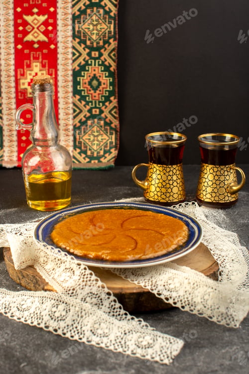 Preview: a front view sweet delicious halva yummy eastern sweet dessert inside plate with tea on the dark