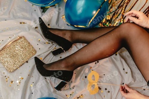 Preview: Woman celebrating New Years Eve. Black tights and high heels. After party. Golden glitter sparkle