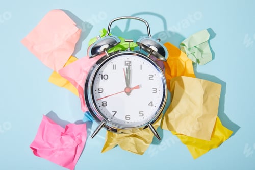 Preview: top view of classic alarm clock with crumpled colorful sticky notes on blue background
