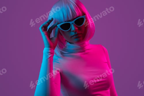 Preview: Stylish futuristic woman adjusting sunglasses