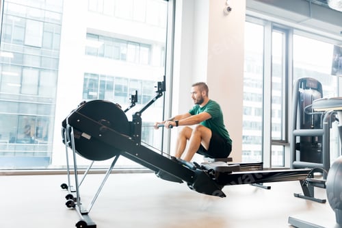 Preview: Active athlete man doing rowing workout