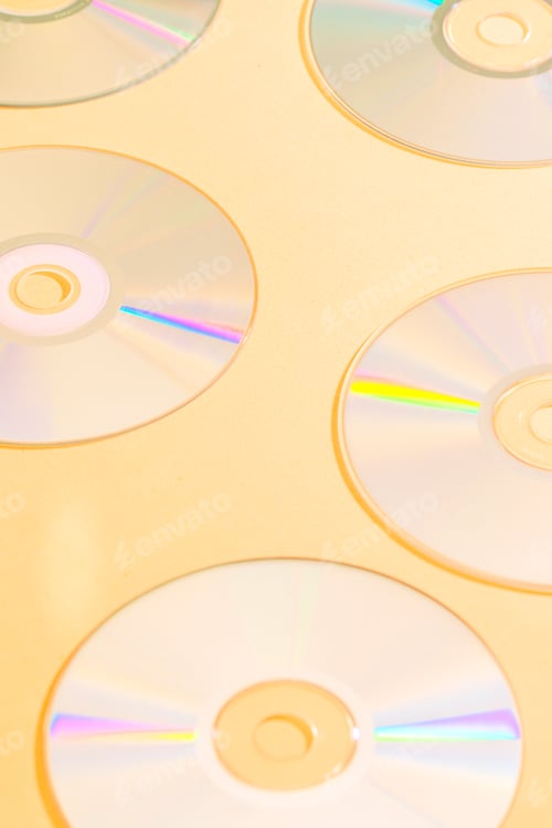 Preview: Silver music discs with reflections on an orange background.