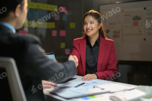 Preview: Business Meeting with Smiling Woman in Red Blazer Shaking Hands in Modern Office Setting