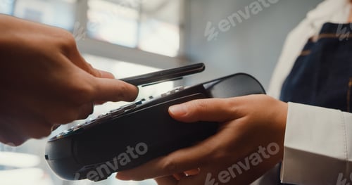 Preview: Young Asia female self service use mobile phone pay contactless with credit card reader machine.