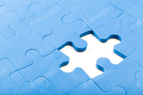 Preview: Puzzle piece missing from a blue jigsaw puzzle in a close-up view