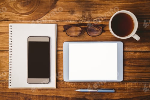 Preview: Smartphone on notepad next to tblet and glasses and cup of coffee on wooden table