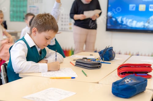 Visualização: lindo garotinho sentado na classe na escola