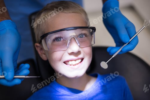 Preview: Dentist examining a young patient with tools