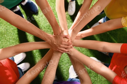 Preview: Group of volunteers joining hands together outdoors, top view