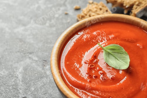 Preview: Bowl with fresh homemade tomato soup on table, closeup. Space for text