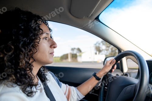 Preview: Woman driving a car on the road.