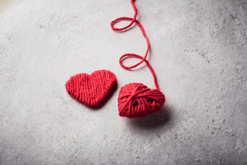 Preview: Red yarn heart shaped on the wall background