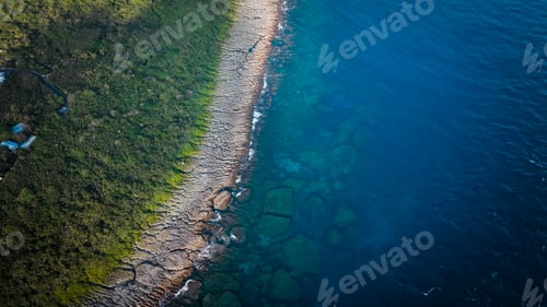 Preview: Aerial view of the rocky shoreline in Taiwan showcasing vibrant blue waters and lush greenery