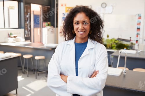 Preview: Female teacher in lab coat smiling in school science room