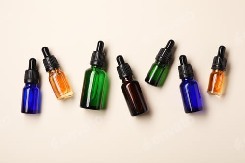 Preview: Flat lay composition with cosmetic bottles of essential oils on color background