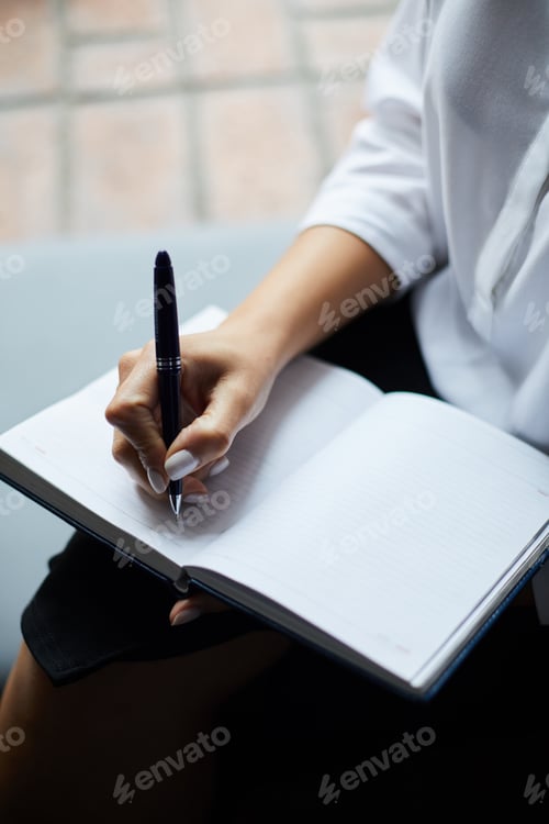 Preview: Businesswoman Writing in Planner
