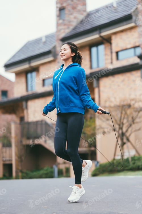Preview: Young Asian woman skipping rope in community
