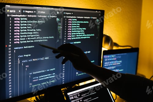 Preview: Man working at night with multiple screens pointing