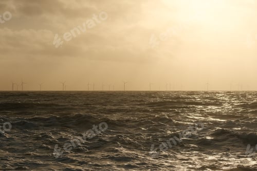 Preview: Wind turbines on the horizon at dusk by the ocean