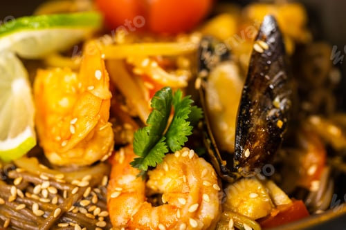 Preview: Udon stir-fry noodles with mussels and shrimp close-up. Asian cuisine