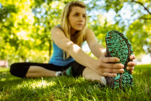Preview: Fit blonde stretching on the grass on a sunny day
