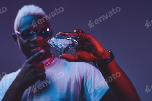 Preview: African man pointing at diamond against dark background