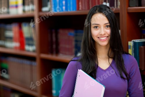 Preview: Happy Young Woman At The Library Holding A Book